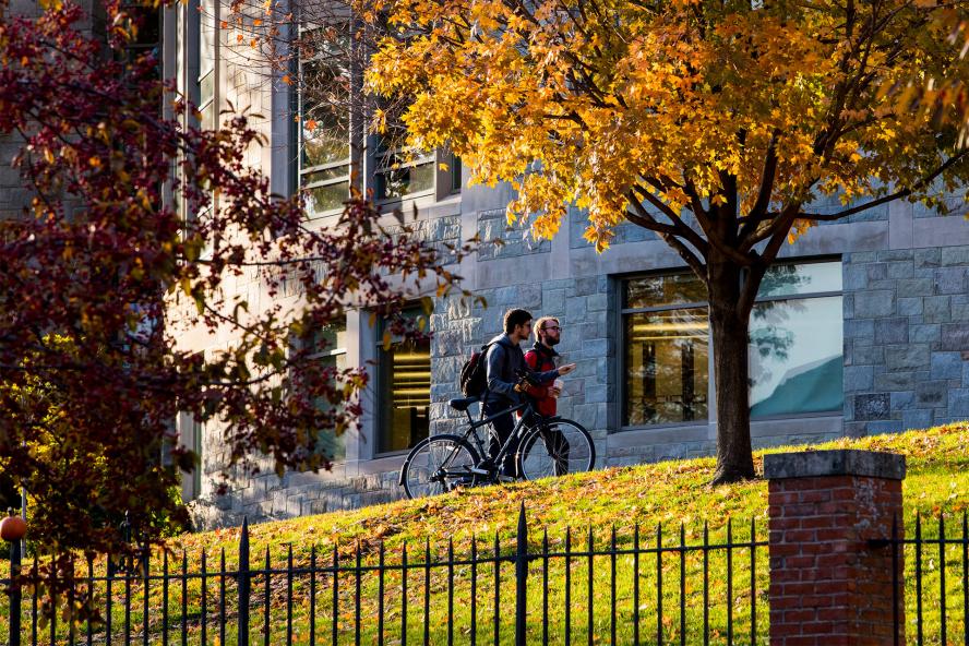 students walk in front of Tisch Library in the fall